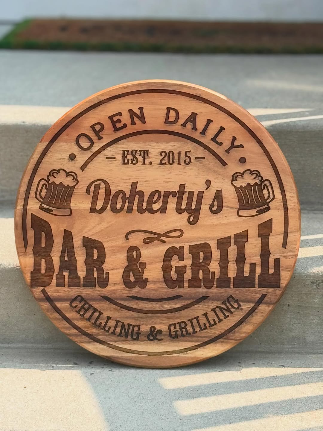 Round engraved hardwood bar sign on the workbench